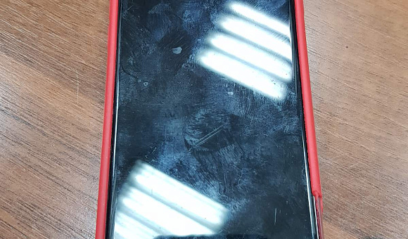 Мобильный телефон IPhone с чехлом красного цвета